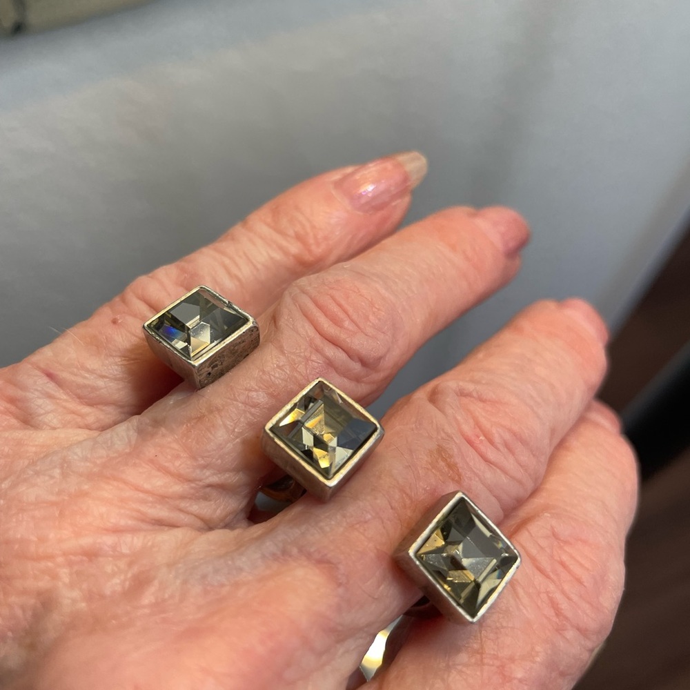 Ring: dazzling & unique. Set between fingers. Faceted squares of silver/gray.